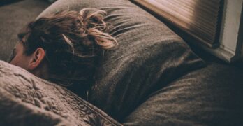 woman sleeping on bed under blankets