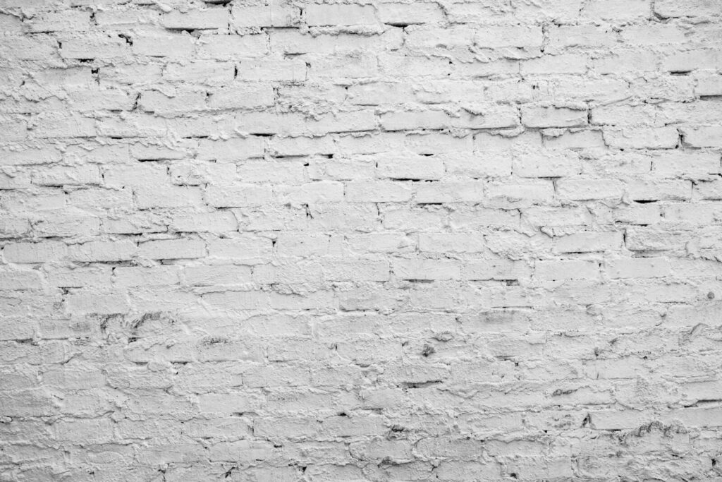 A detailed close-up of a white brick wall with rough stucco texture, ideal for backgrounds.