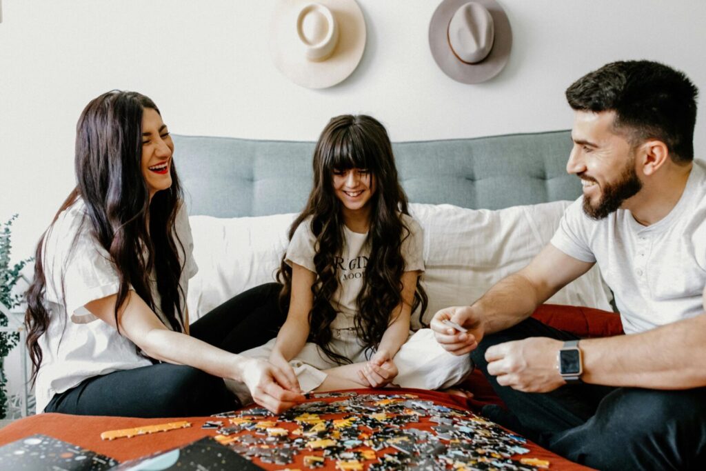 A family joyfully assembles a puzzle together, creating a heartwarming indoor scene full of smiles.