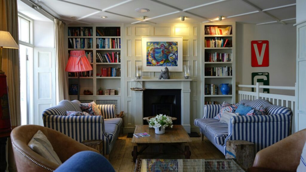 Stylish living room with modern decor, striped couches, and a cozy fireplace.
