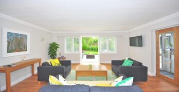 Modern living room with stylish furniture, wooden flooring, and bright decor in a spacious layout.