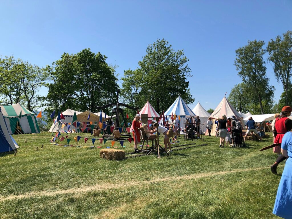 a group of people standing in a field next to tents