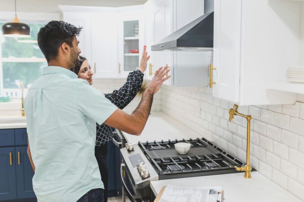 A real estate agent demonstrates kitchen features in a modern home. Ideal for real estate and lifestyle concepts.