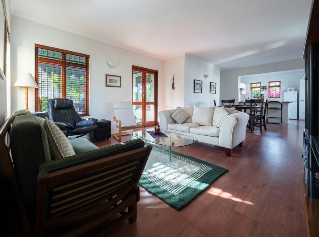 Spacious living room with modern furniture and wooden flooring.
