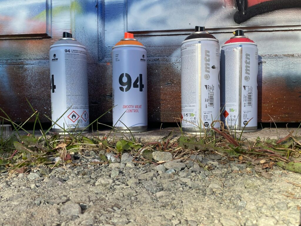 three cans of spray paint sitting next to each other