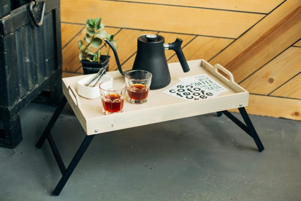 Modern folding table setup with teapot and coffee for a cozy indoor atmosphere.