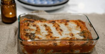 Savory baked lasagna in a glass tray on a burlap tablecloth, ready to serve.