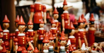 Close-up of handmade wooden Pinocchio toys at a market. Perfect for traditional and souvenir themes.