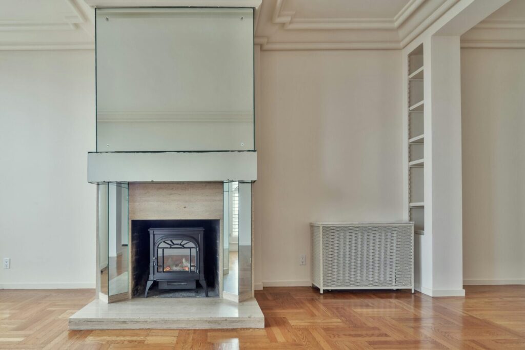 Spacious modern living room featuring a sleek mirrored fireplace and parquet flooring.
