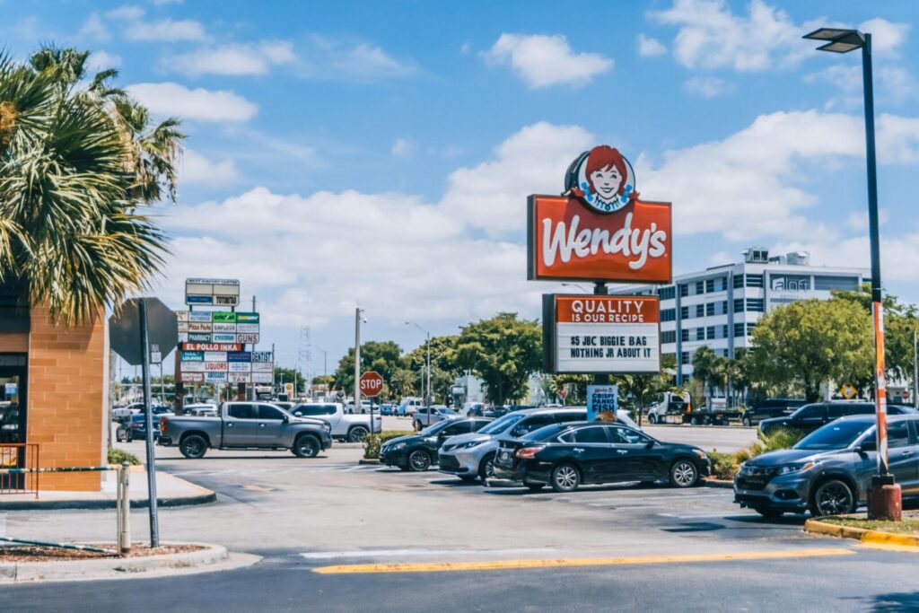 Wendy's parking area crowded with cars under a clear blue sky in Orlando.
