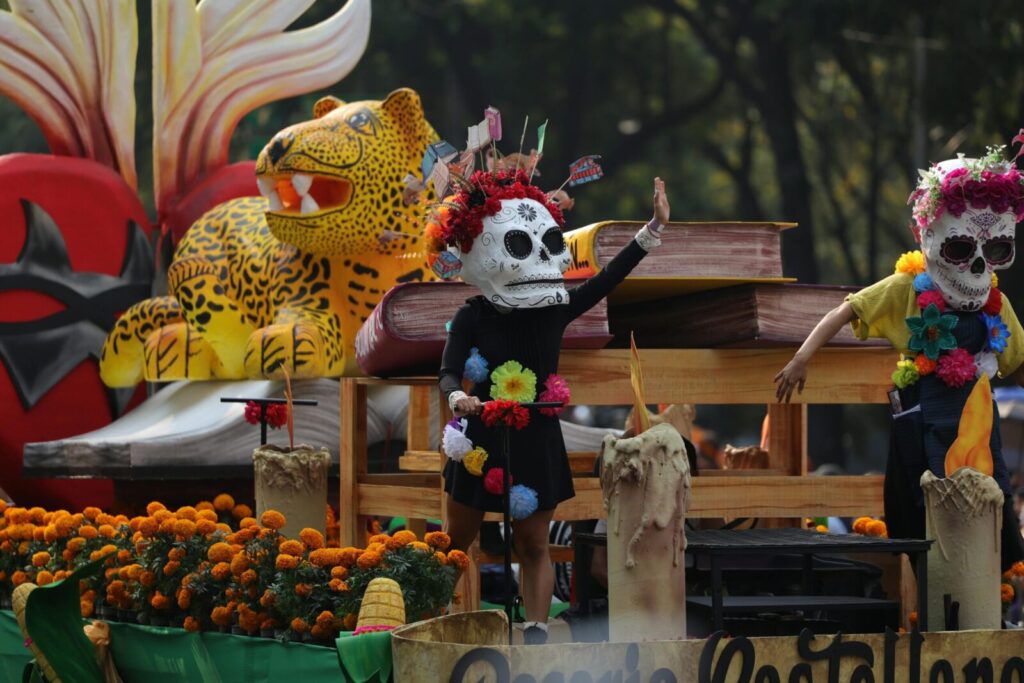 Festive Day of the Dead parade with colorful costumes and marigolds in Mexico City.