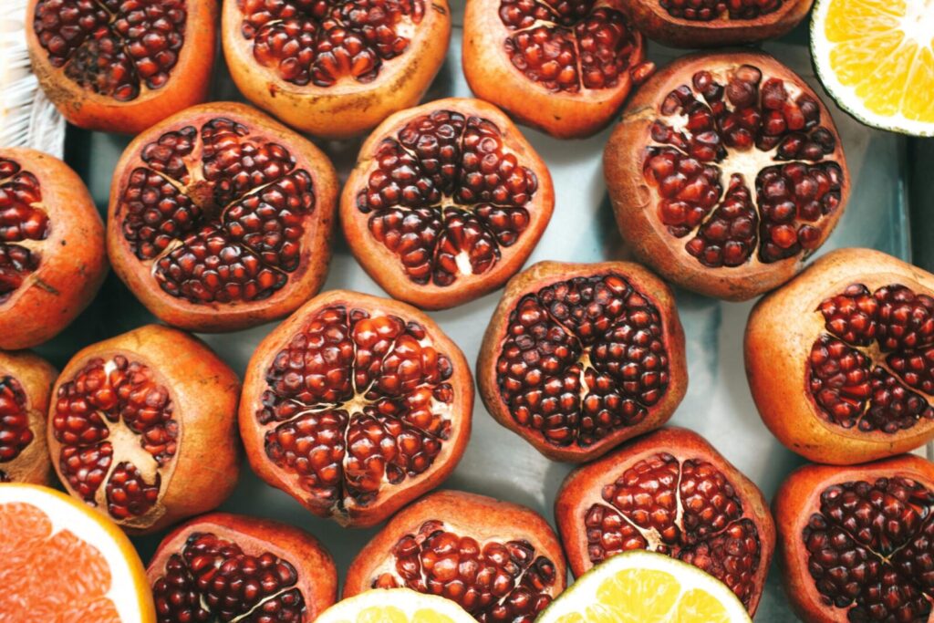 Top view of sliced pomegranates and citrus fruits, showcasing freshness and vibrant colors.