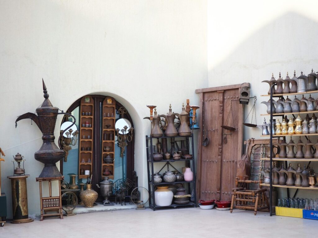 An outdoor display against a textured wall, showcasing vintage artifacts and curved wooden doors.