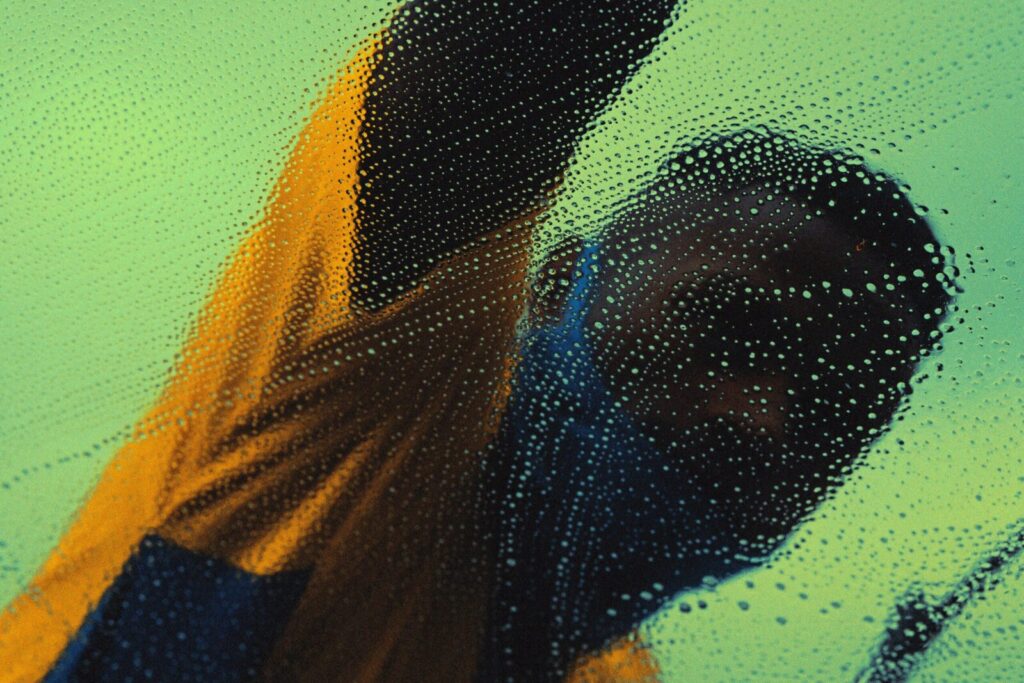 Anonymous man in São Paulo washing glass with soap and bubbles, creating a blurred effect.
