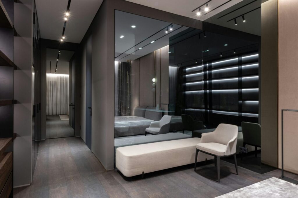 Interior design of bedroom with modern furniture and big mirror on wall in flat