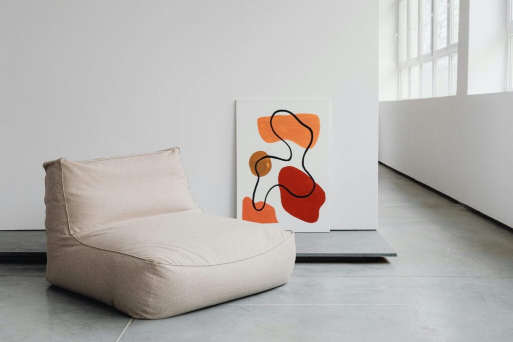 A contemporary interior featuring abstract artwork and a minimalist chair.