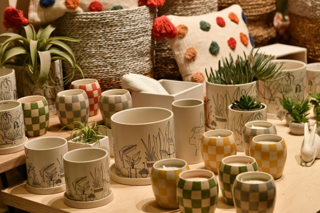 A display of decorative ceramic pots and baskets with plants.