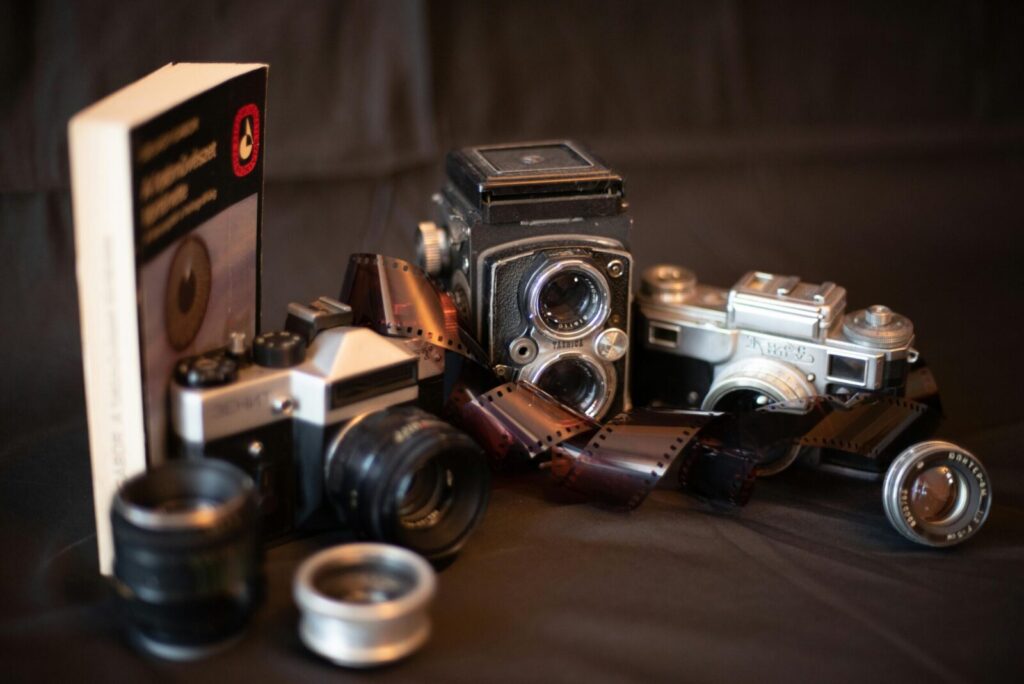 A vintage collection of cameras and film rolls showcasing classic photography equipment.