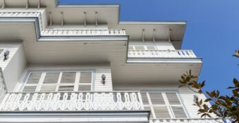 A tall white building with balconies and balconies