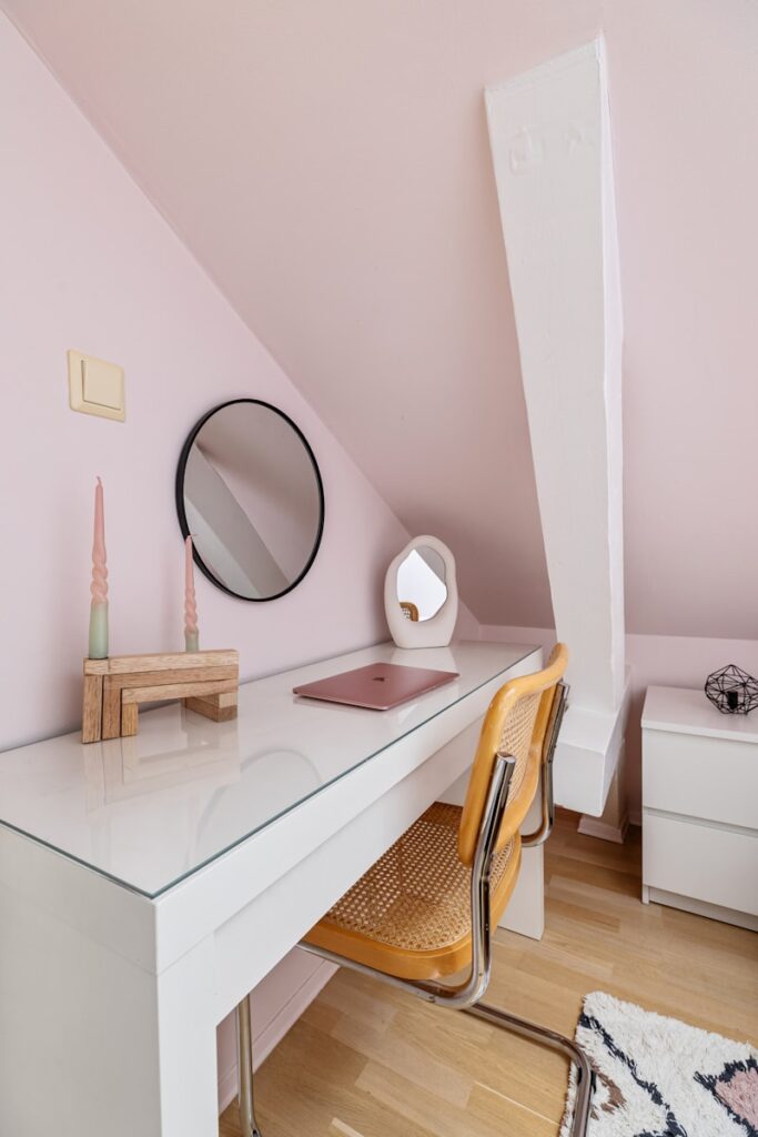 A desk with a mirror and a chair in a room