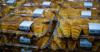 a close up of many pastries in plastic containers