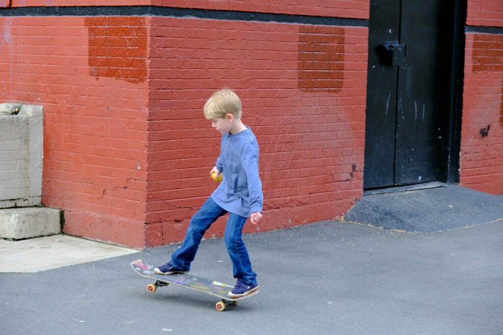 a young boy riding a skateboard down a street