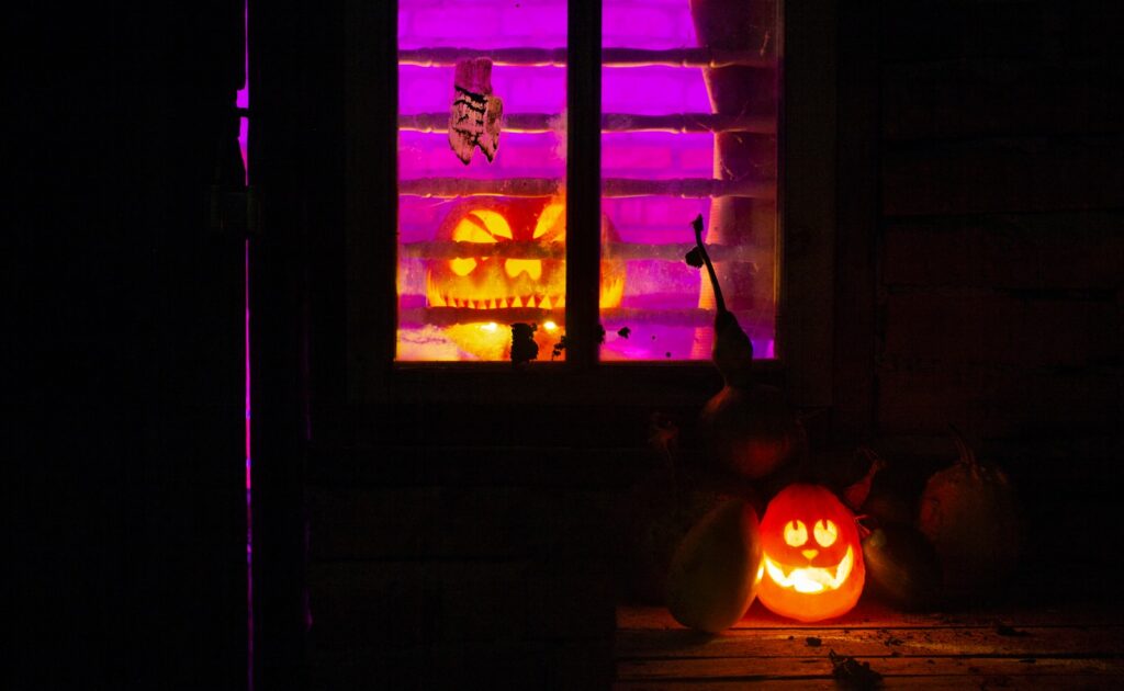 a couple of pumpkins sitting in front of a window