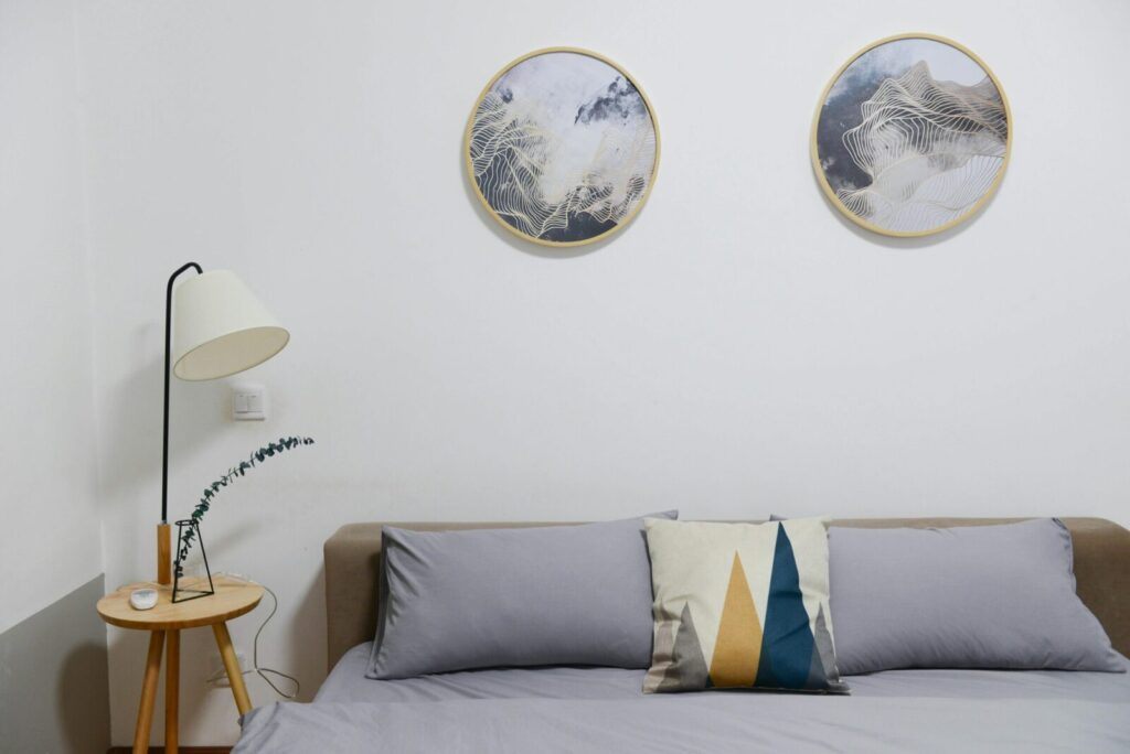 Stylish modern bedroom featuring minimalist decor with abstract wall art and cozy furniture.