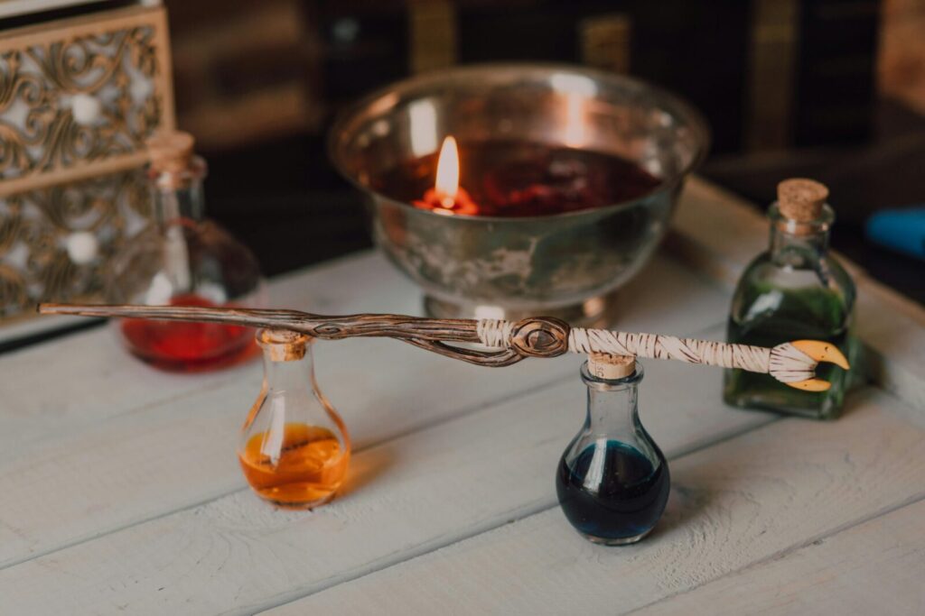 Intriguing display of a magic wand and colorful potion bottles in an artistic setting.