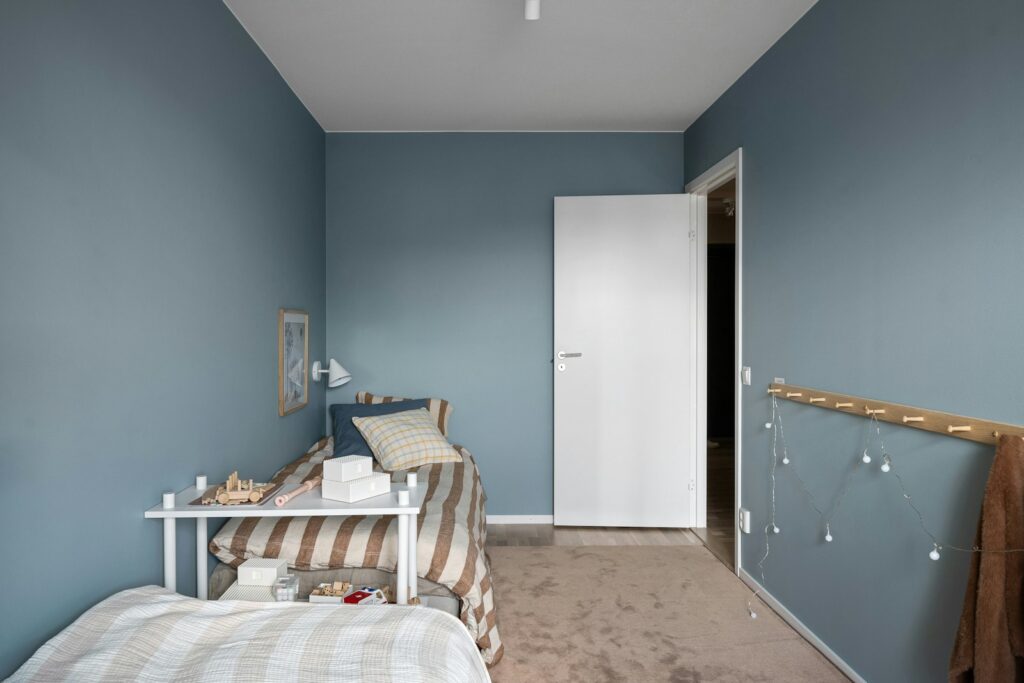 A bedroom with blue walls and a bed