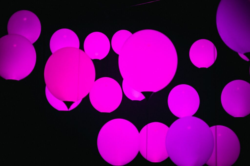 Pink and purple orbs glow in the dark.