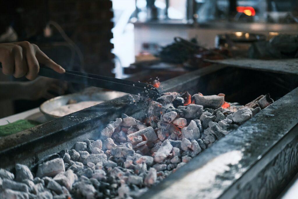 A person cooking food on a grill in a kitchen