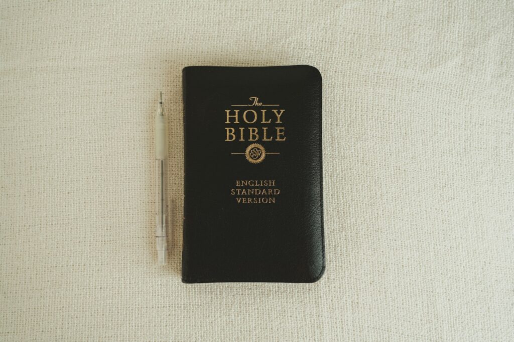 a black bible with a pen on top of it