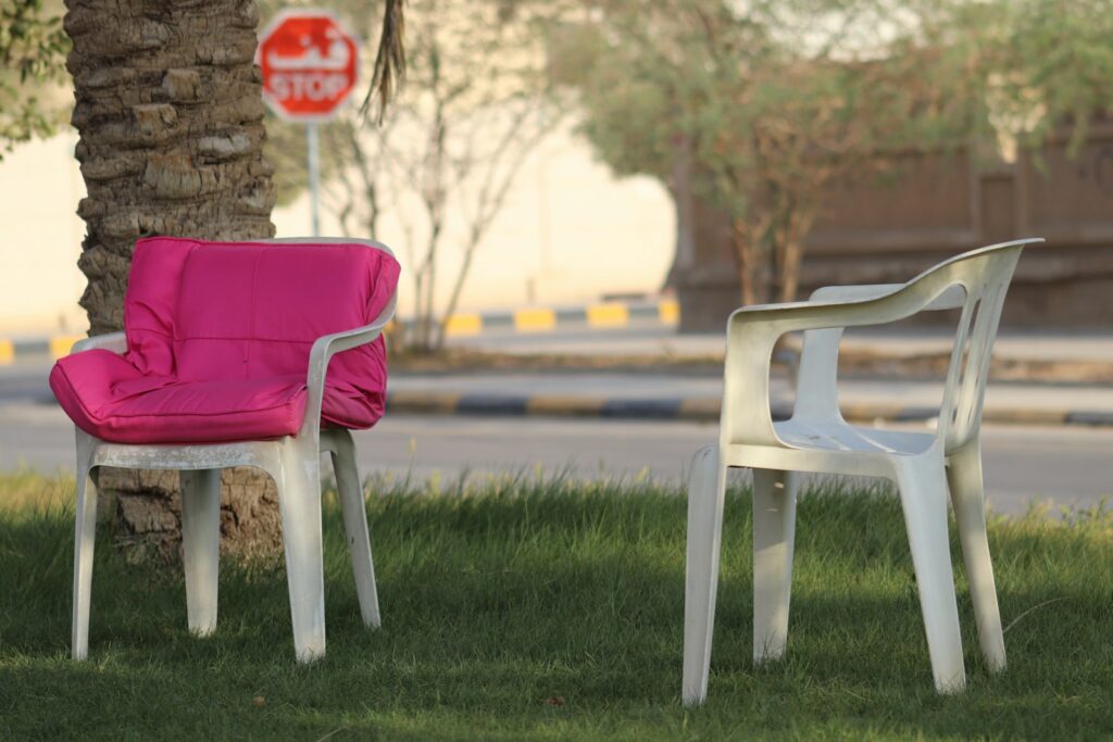 a couple of chairs sitting on top of a lush green field