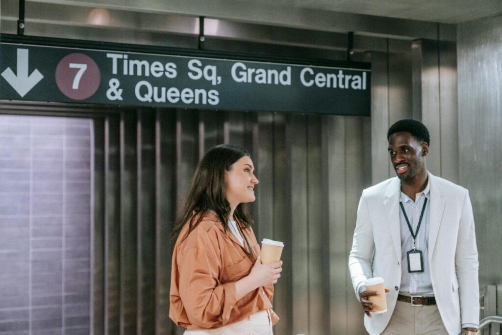 A diverse group of professionals chatting over coffee at Times Square subway station.