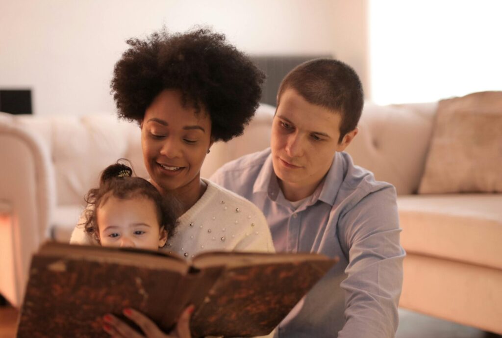 A happy family reads together on a comfortable sofa, showcasing love and togetherness.