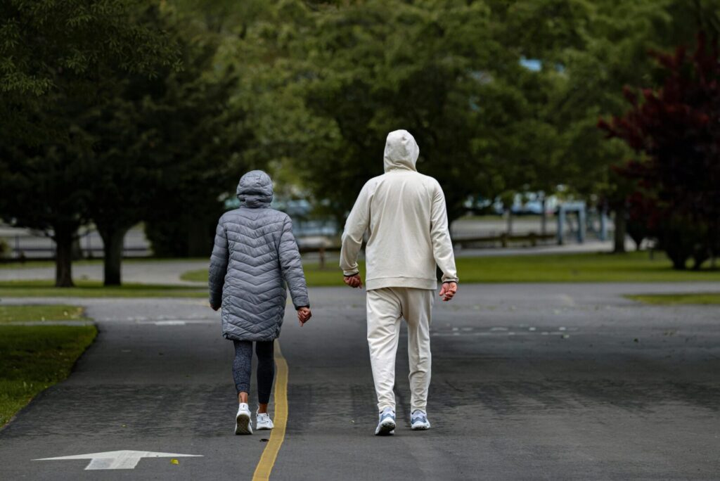 A couple enjoying a stroll at Cove Island Park in Stamford, Connecticut, surrounded by lush greenery.
