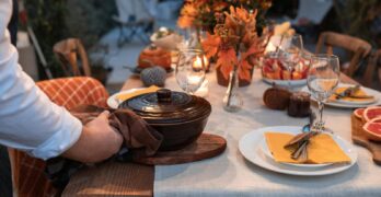 Beautifully arranged autumn table setting with festive decorations and a serving pot.