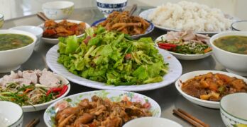 A table is filled with delicious vietnamese food.