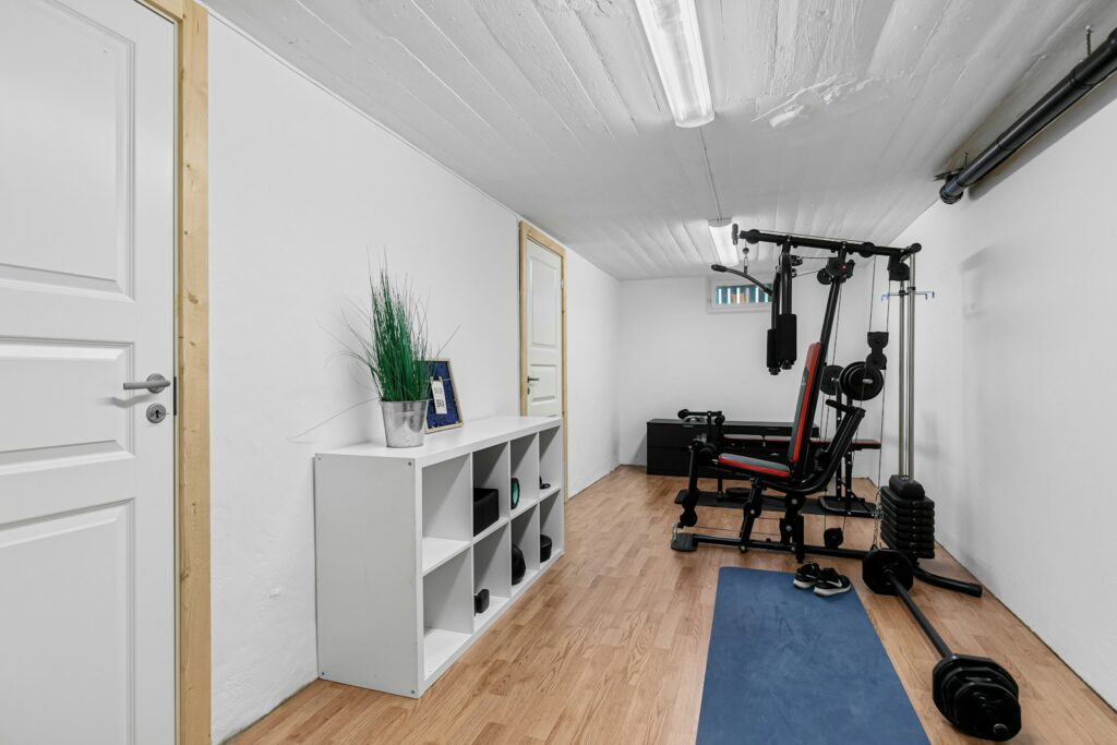 A home gym with a blue mat and exercise equipment
