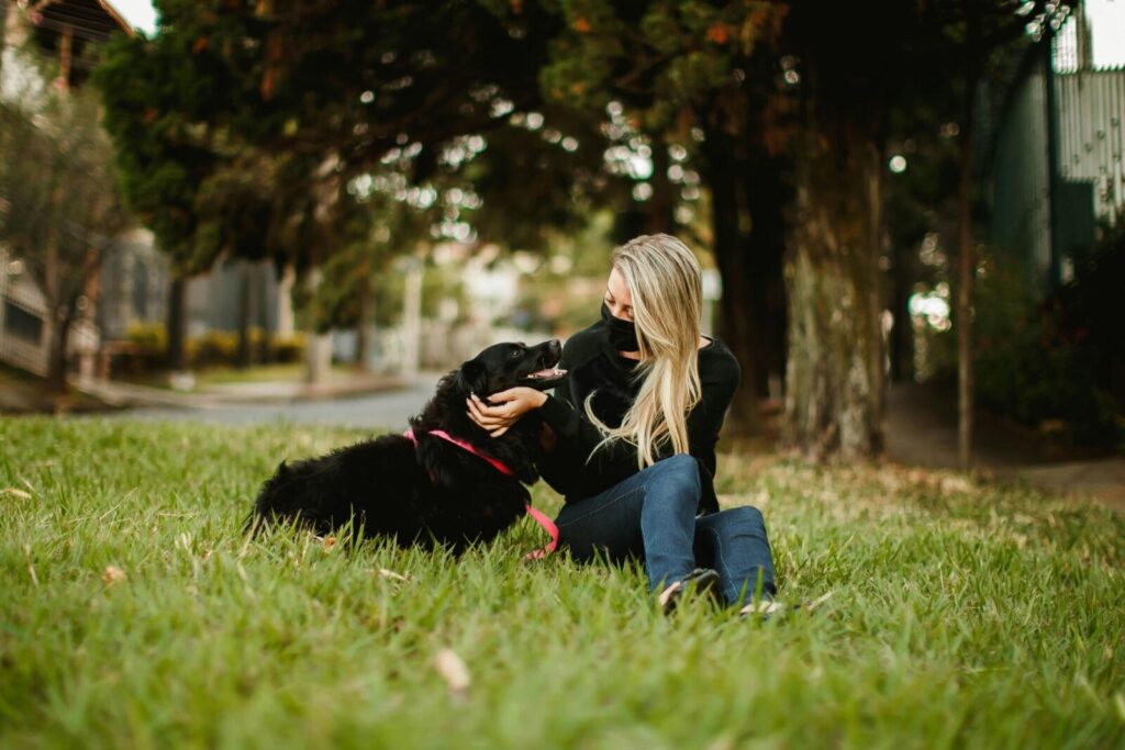 Woman and her dog bonding in a serene park setting, capturing a moment of companionship and tranquility.