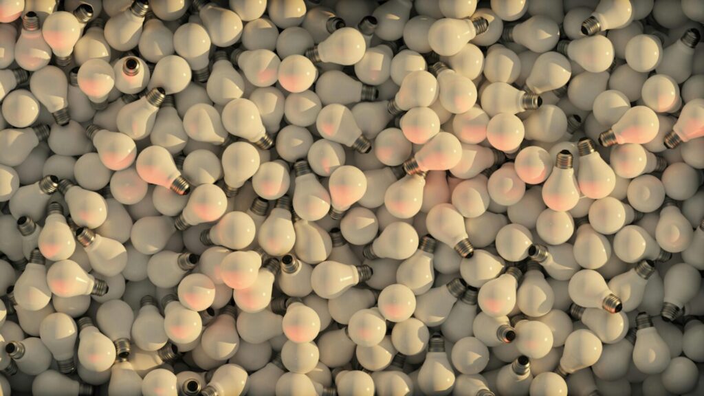 Aerial view of a colorful pile of incandescent light bulbs creating a radiant and dynamic texture.