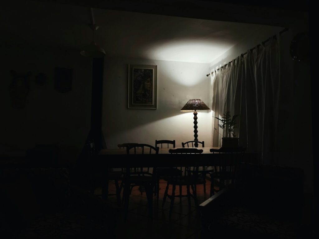 a dark room with a table and a lamp
