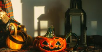 a pumpkin sitting on top of a table next to a lantern