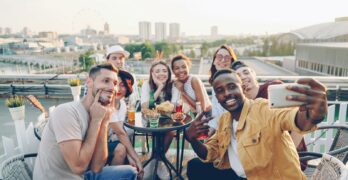 Group of friends taking a selfie on a rooftop.