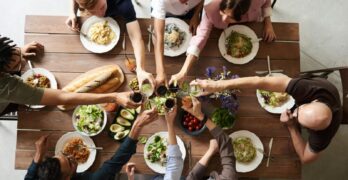 A vibrant group cheers over a delicious meal, showcasing friendship and togetherness.