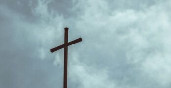 brown wooden cross under cloudy sky during daytime