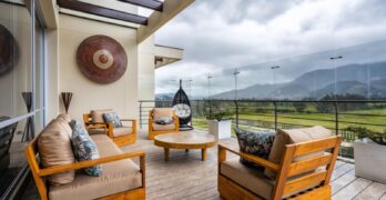 Stylish outdoor space featuring wooden furniture and mountainous backdrop in Sopó, Colombia.