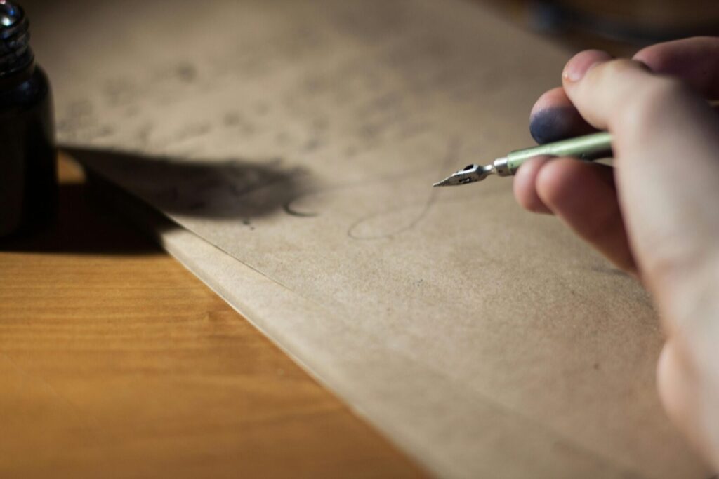Close-up of a hand writing with a fountain pen on vintage paper, capturing the art of calligraphy.
