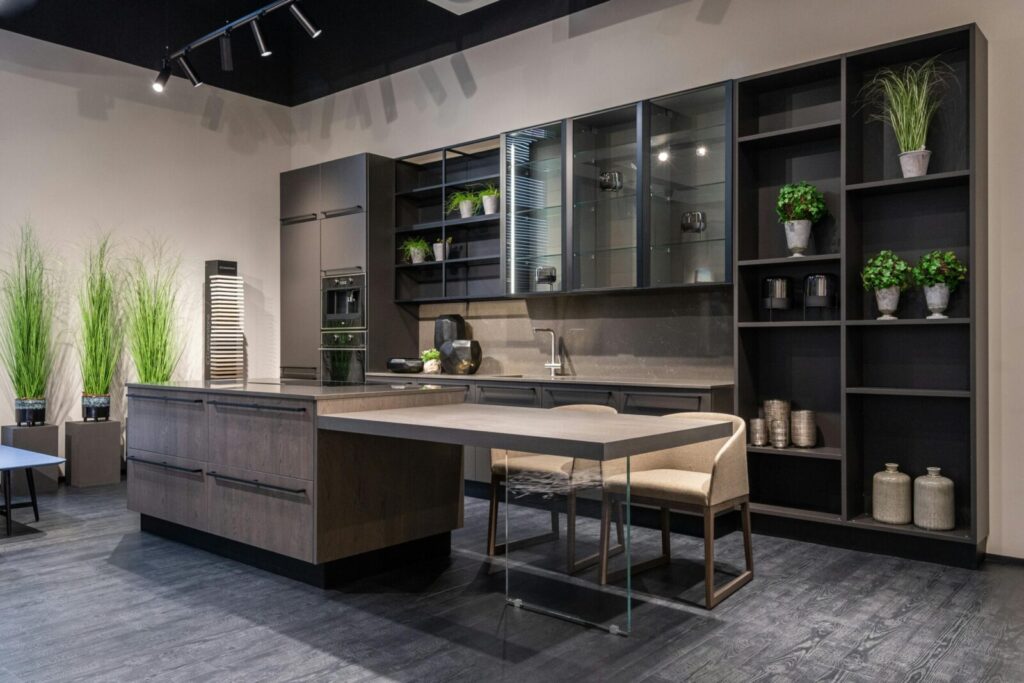Sleek modern kitchen featuring a spacious island, indoor plants, and elegant shelving.